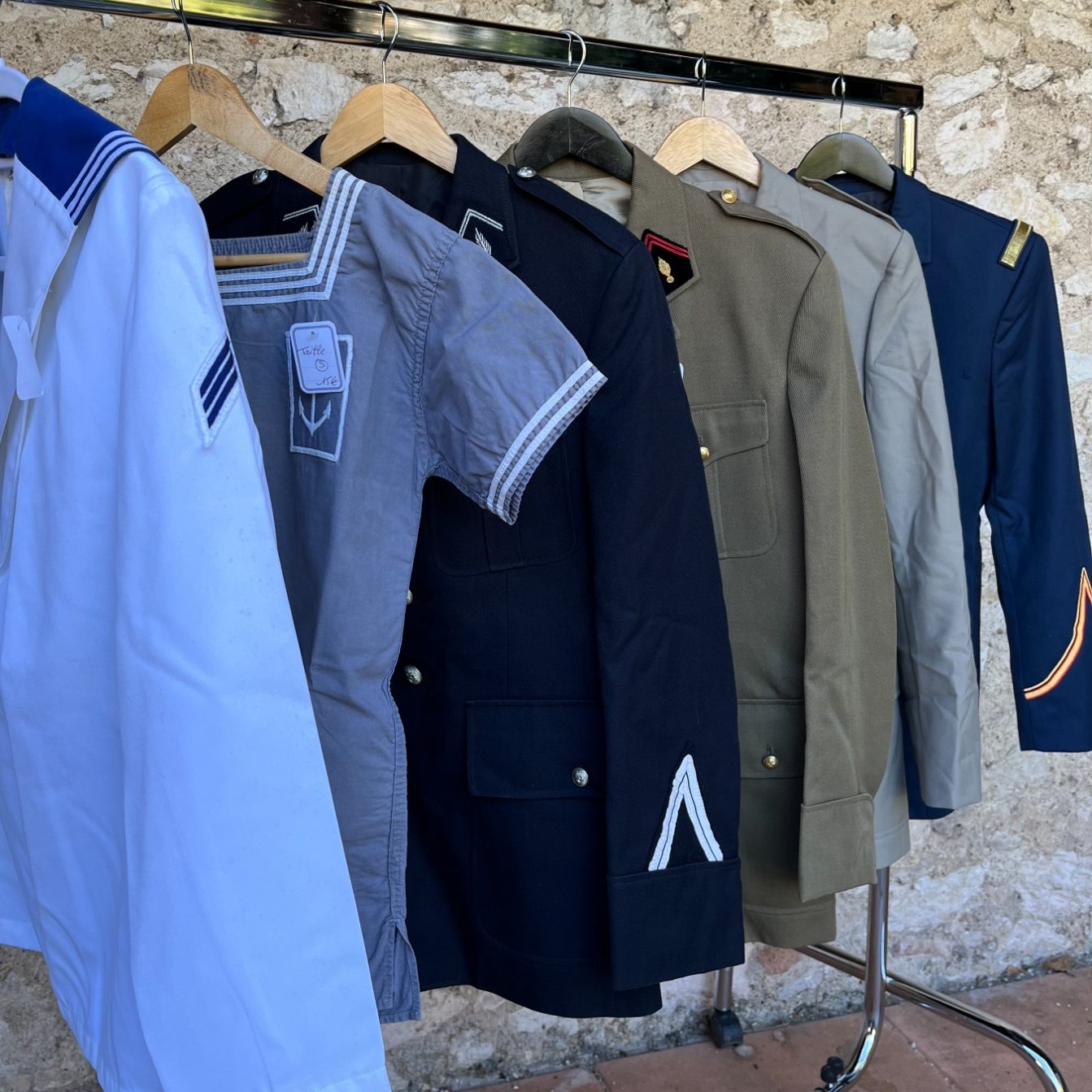 destock-and-compagny, vêtements costumes uniformes militaire de l'armée française uniformes militaire armée française de différentes couleurs et de régiments accrochés à un portant.